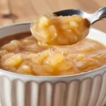 A freshly made bowl of homemade applesauce with apples and cinnamon.
