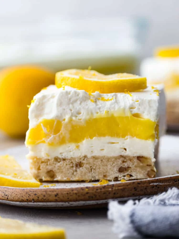 Delicious lemon cream cheese bars served on a plate with fresh lemon slices