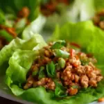 A plate of tasty Asian lettuce wraps filled with vegetables and protein