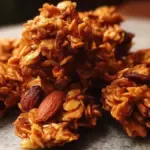 Honey Almond Granola Clusters in a bowl with a sprinkle of almonds and honey
