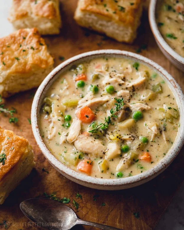 Bowl of Chicken Pot Pie Soup garnished with herbs and flaky pastry crust