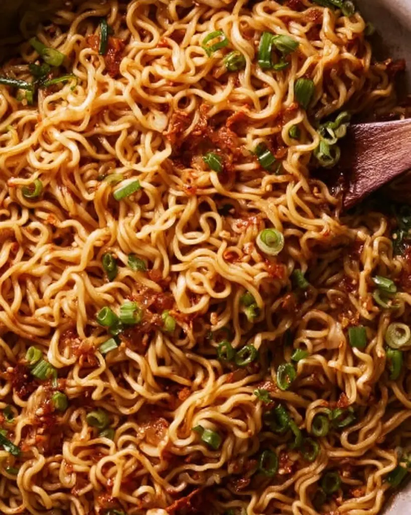 A bowl of easy garlic chili oil noodles garnished with fresh herbs