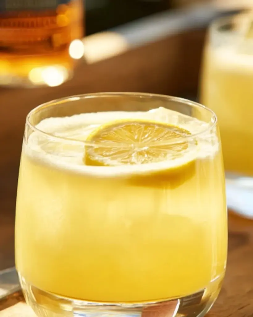 Pineapple Whiskey Sour cocktail in a glass with a pineapple garnish