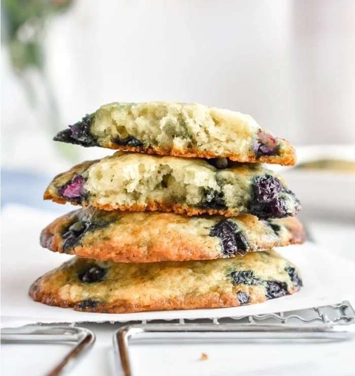 Freshly baked blueberry muffin tops with juicy blueberries and a golden crust.