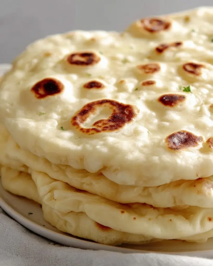 Freshly baked homemade naan bread served on a plate